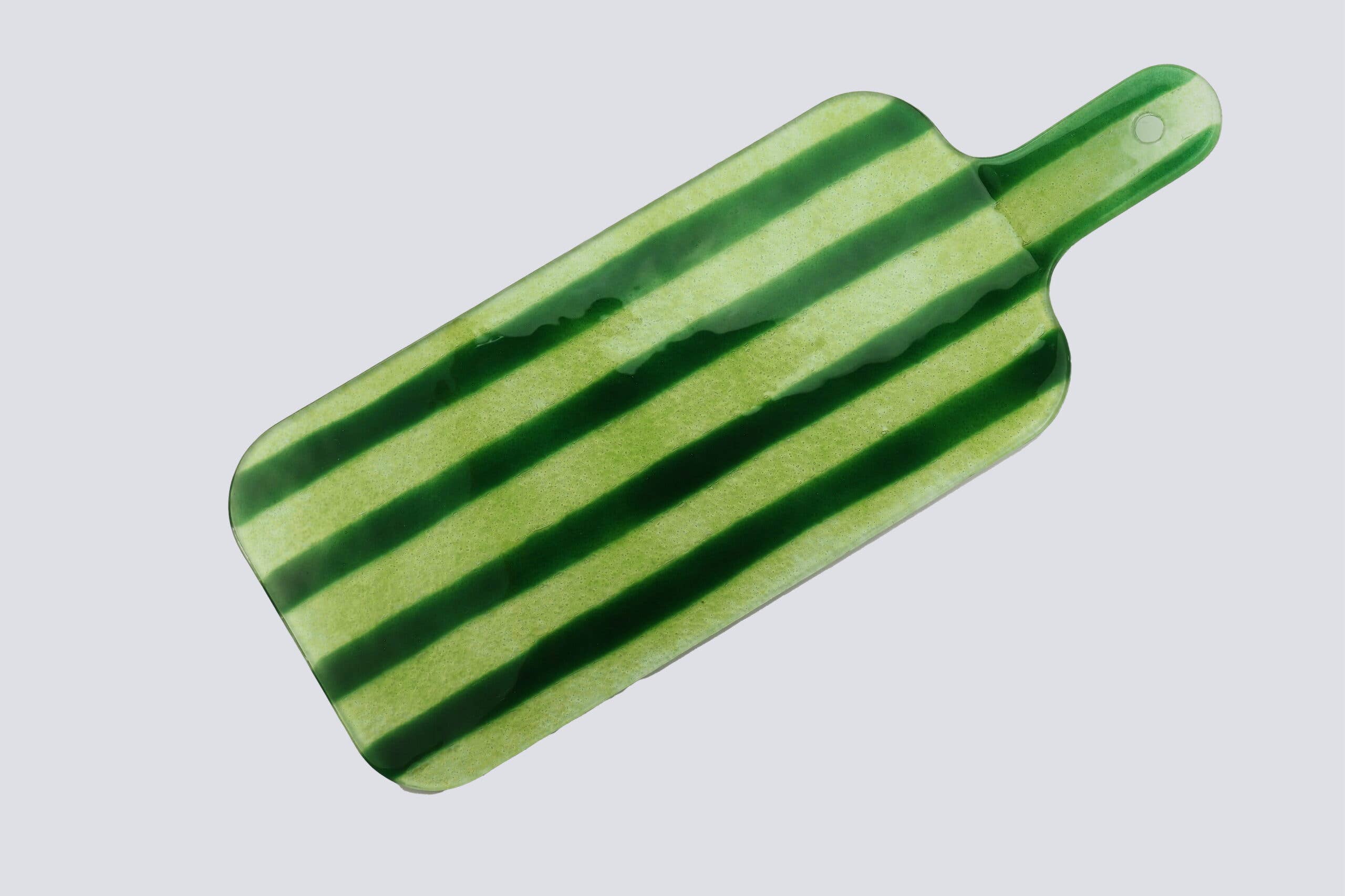 Bovenaanzicht glazen borrelplank met groene strepen op een witte achtergrond.