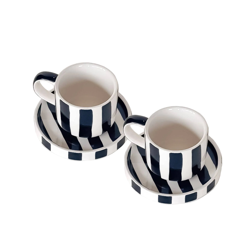 Bovenaanzicht espresso kop en schotel met zwart en witte strepen op een witte achtergrond.