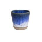 Vooraanzicht espressokopje met blauw/witte overloop op een witte achtergrond.