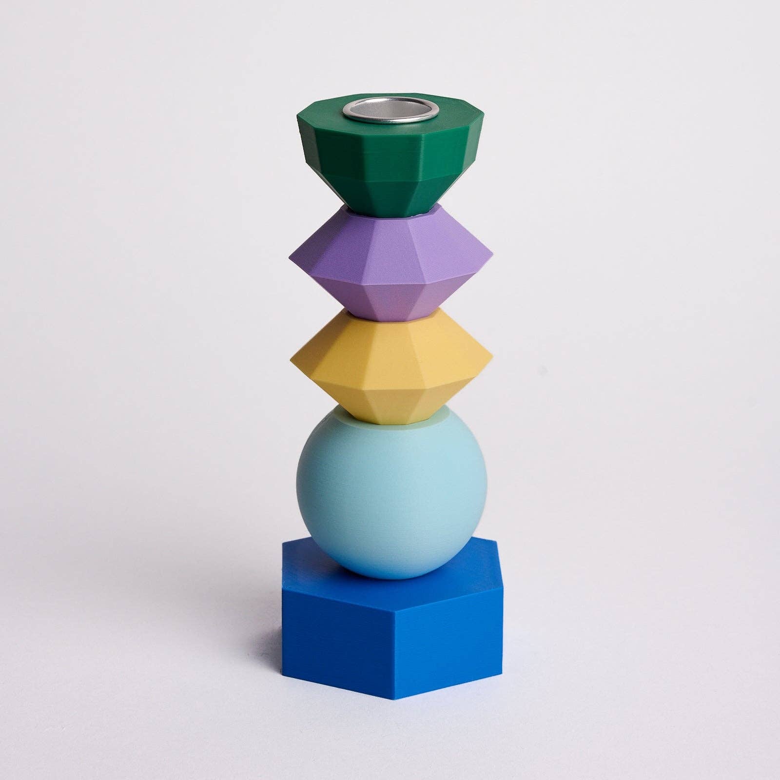Kandelaar met verwisselbare componenten in de kleuren donkergroen, mosterdgeel, lichtblauw, lichtpaars en donkerblauw.