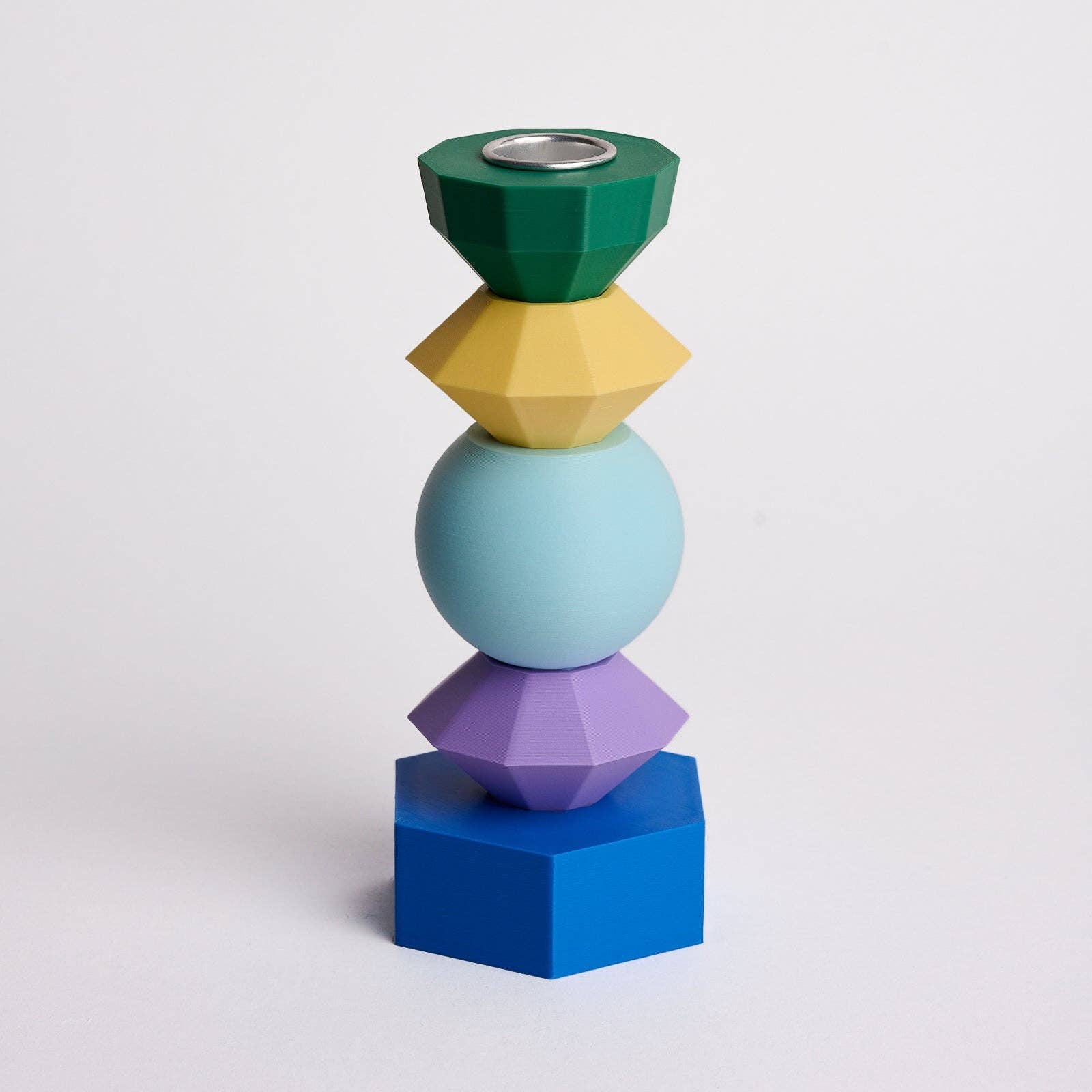 Kandelaar met verwisselbare componenten in de kleuren donkergroen, mosterdgeel, lichtblauw, lichtpaars en donkerblauw.