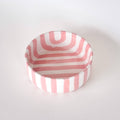 Schaaltje met roze en witte strepen op een witte achtergrond. Bovenaanzicht.