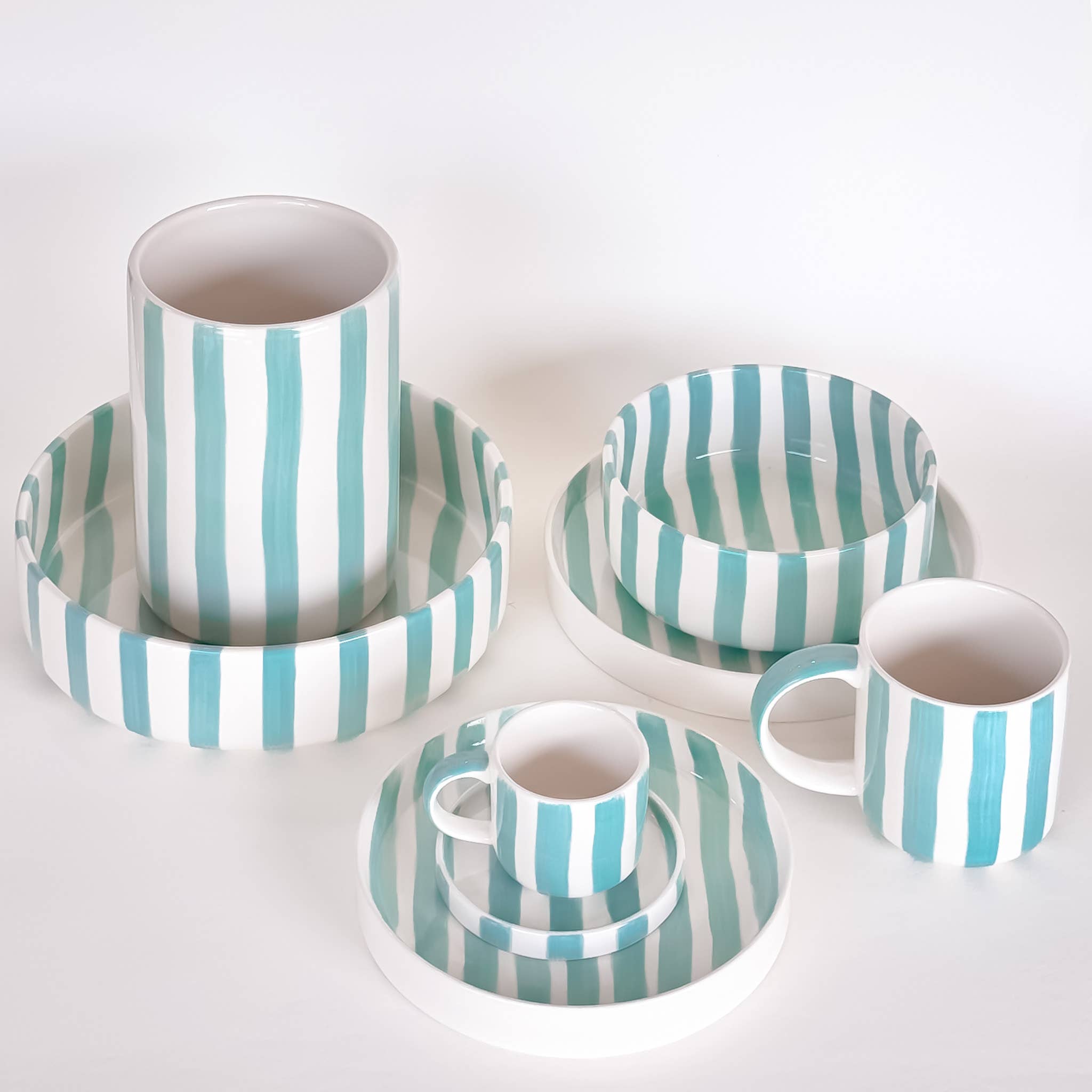 Divers servies van Magazin Minori met strepen in mintgroen met wit op een witte achtergrond.