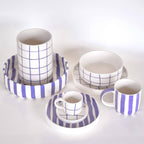Divers servies van Magazin Minori in wit en paars met diverse patronen op een witte achtergrond.