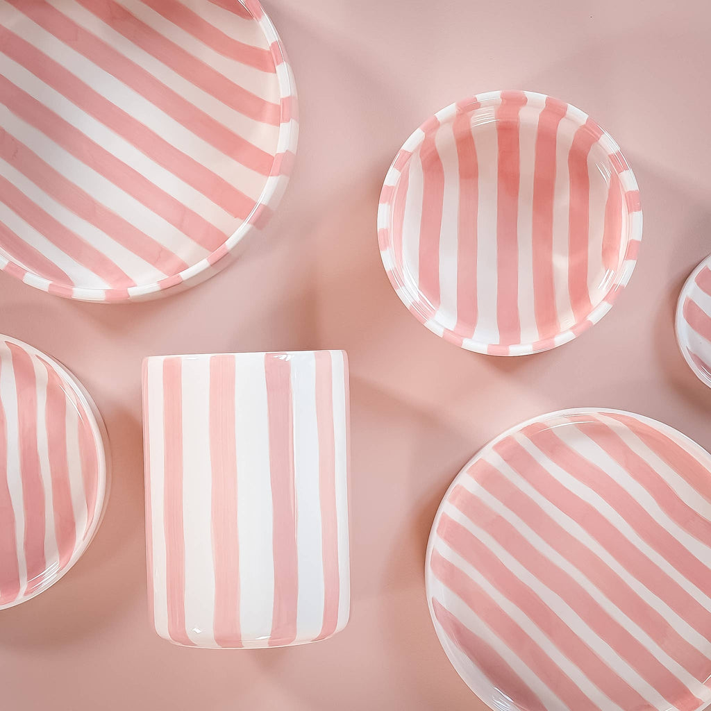 Divers servies van Magazin Minori met roze en witte strepen op een lichtroze achtergrond.
