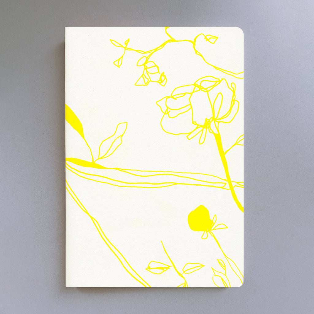 Wit notitieboekje met gele bloemen op een witte achtergrond.