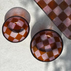 Bovenaanzicht van twee schaaltjes van glas met geblokt motief in de maten S en XS op een beige achtergrond.