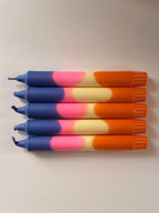 5 handgemaakte Dip Dye kaarsen in blauw, roze, geel en oranje op een witte achtergrond