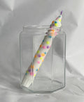 Witte handgemaakte dip dye kaars met confetti stippen in pastel kleuren in een glas